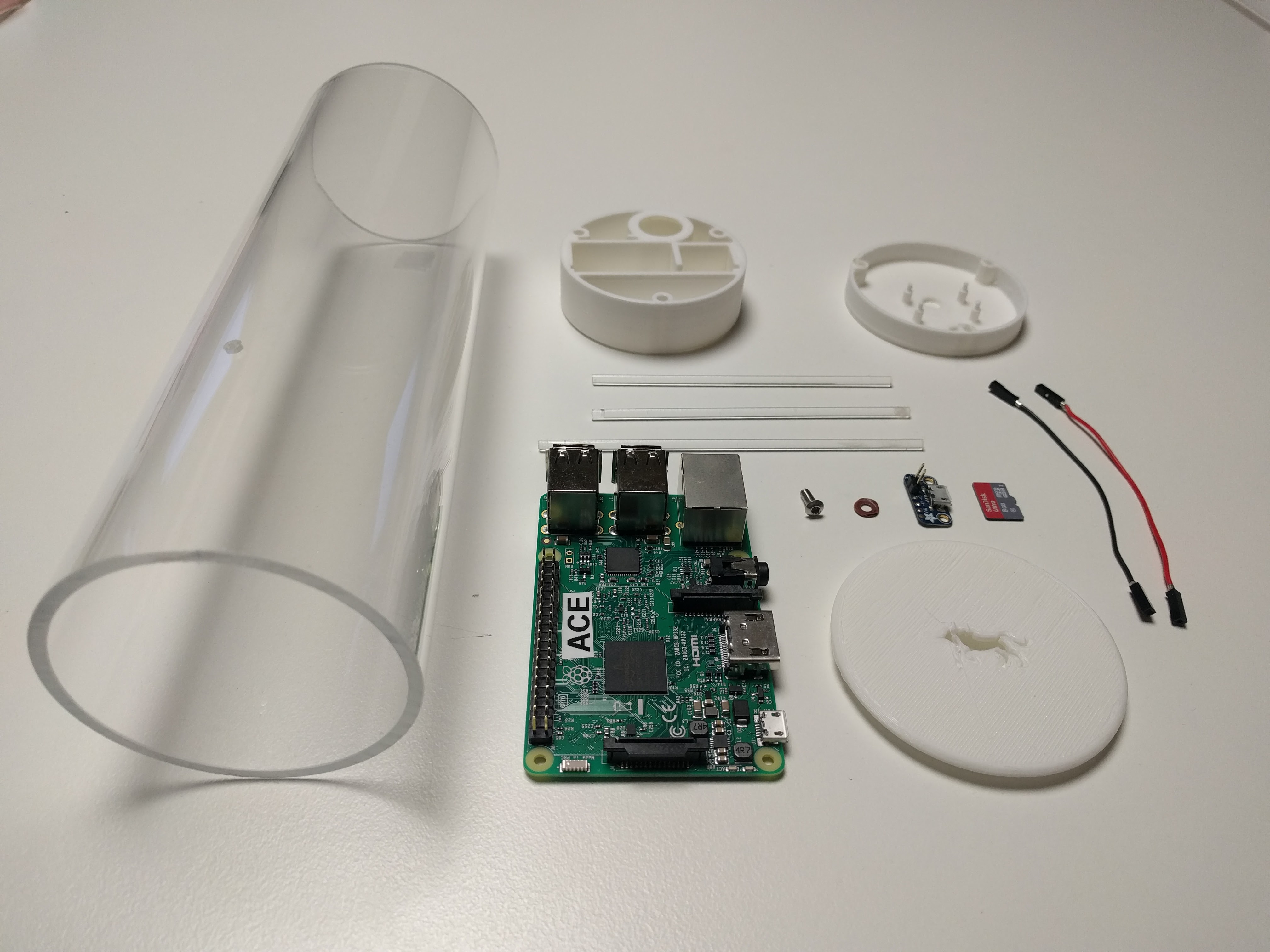 The parts of a single agent laid out flat: a clear acrylic tube, 3D-printed end caps, a Raspberry Pi labelled "ACE", a sensor board, an SD card, and jumper wires