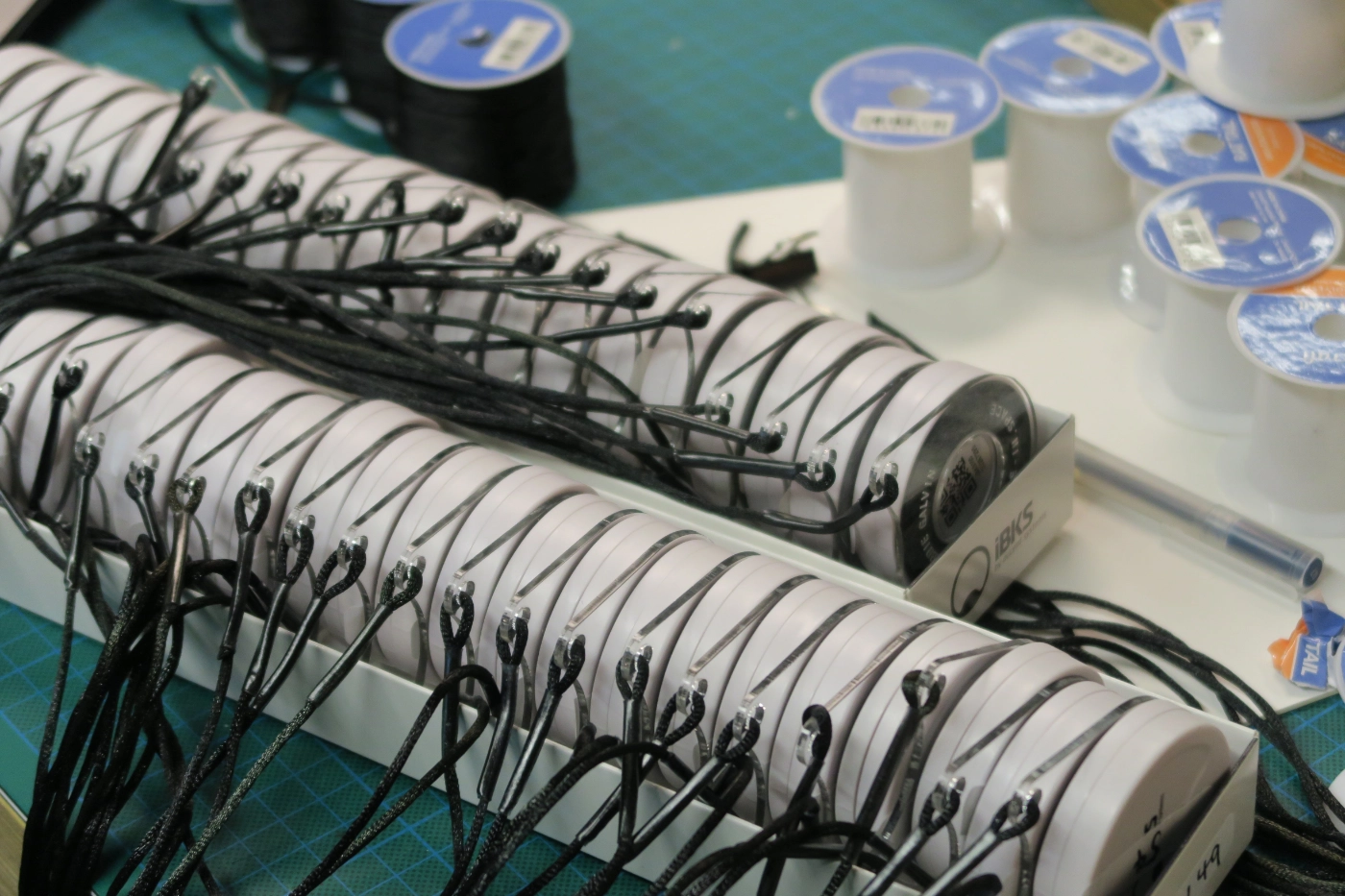 A large array of beacons in setup stacked neatly in a row on a craft table.