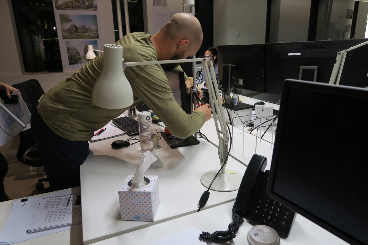 A man is installing the Raspberry Pi agent on a desk, behind a computer monitor.